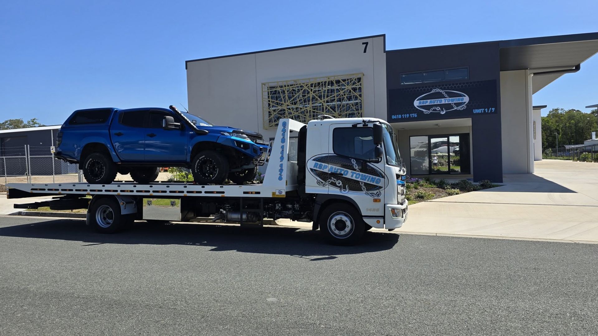 Tow truck twing a blue 4 wheel drive